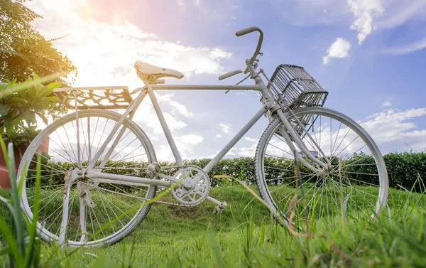 Bicicleta branca no céu de fundo do gramado e nuvens brancas . — Fotografia de Stock