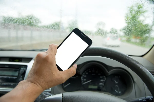 La gente juega teléfonos inteligentes mientras conduce el coche, la carretera está lloviendo u — Foto de Stock