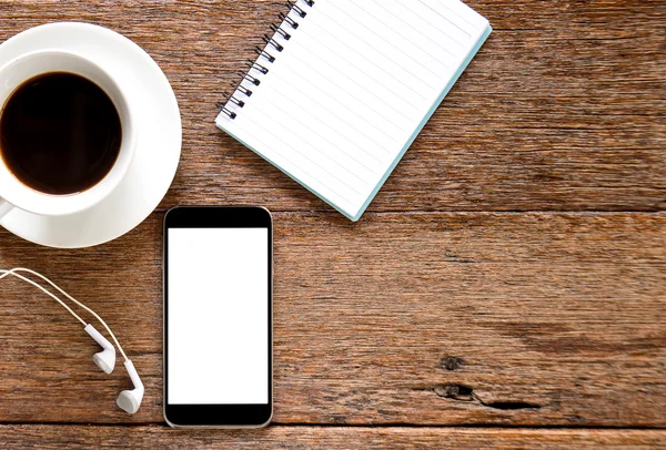 Smart telefon, hörlurar och anteckningsboken med kaffe på trägolv. — Stockfoto