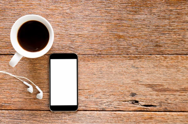 Smart telefon och hörlurar med kaffe på trägolv. — Stockfoto