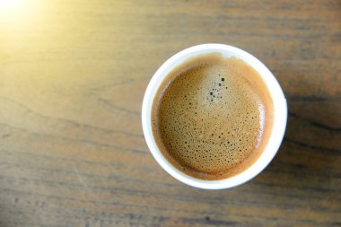 Ahşap masa üzerinde beyaz kağıt bardak kahve.