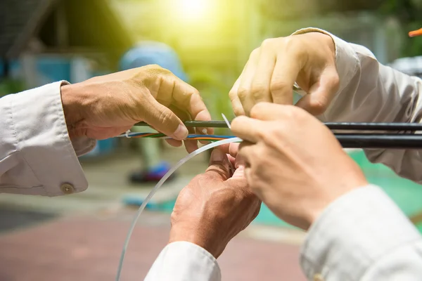 Les techniciens installent la fibre optique avec des attaches de câble. — Photo