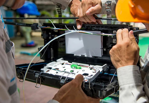 Los técnicos instalan el gabinete en el cable de fibra óptica . — Foto de Stock