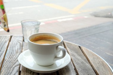 Beyaz kahve Kupası ve cam su ahşap tablo.