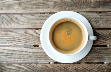 ahşap masa üzerinde beyaz kahve fincanı.