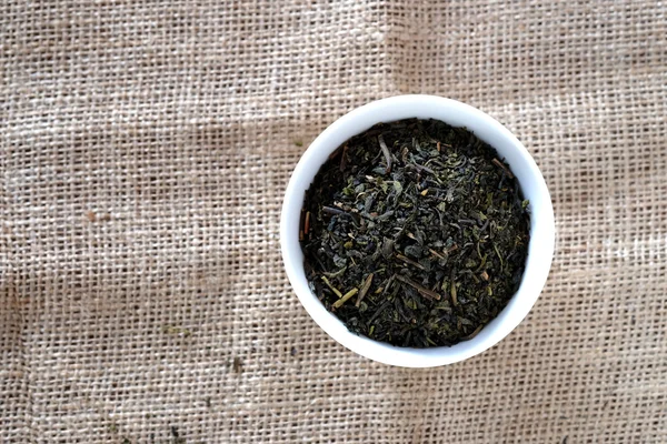 Tee in weißer Tasse mit Sacktuchboden. — Stockfoto