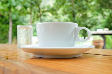 Ahşap table.blurred yeşil backg üzerinde su beyaz kahve ve cam