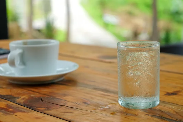 Weißer Kaffee und Glaswasser auf einem Holztisch. — Stockfoto