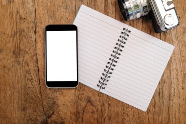 Ahşap zemin üzerinde klasik kamera ile dizüstü akıllı telefon.