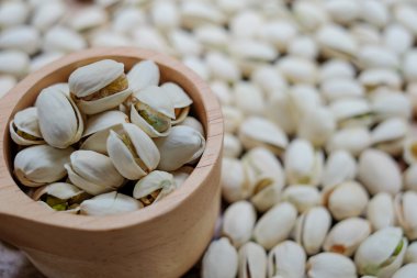 Fıstıklı arka plan ile ahşap kase fıstık fındık.