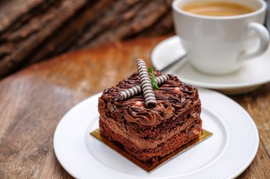 Çikolatalı kek ve kahve fincanı ahşap üzerinde.