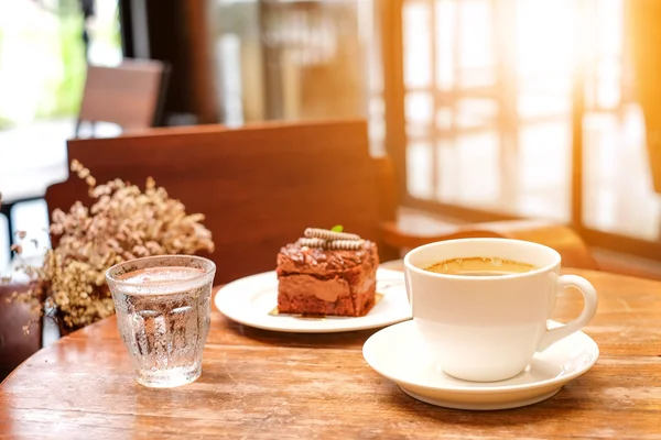 Schokoladenkuchen und Kaffeetasse auf Holz. — Stockfoto