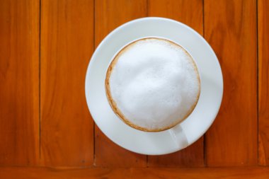 Ahşap zemin üzerinde beyaz geç kahve.