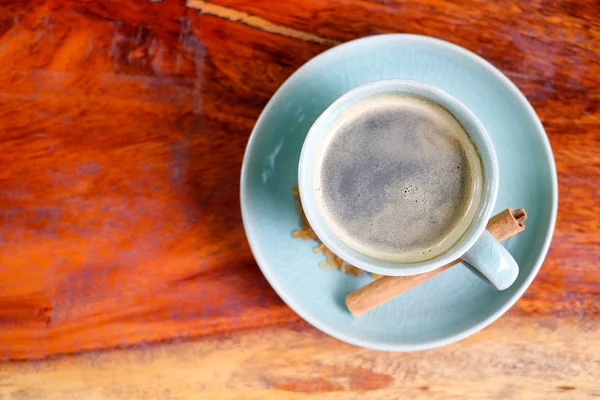 Filiżanka kawy na drewnianym stole z cynamonem i brązowy cukier. — Zdjęcie stockowe