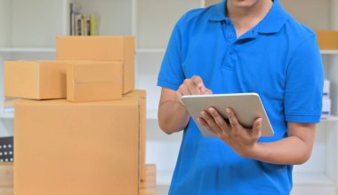 Kurye teslimat bilgilerini kaydetmek için bir tablet kullanıyor..