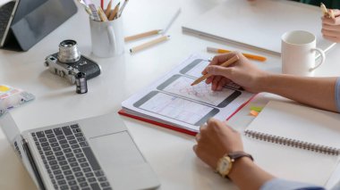 Smartphone uygulama tasarımcılarının kırpılmış görüntüleri müşterileri göstermek için yeni projeler tasarlıyor.