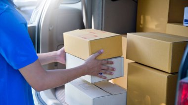 Kurye teslimat için karton kutuyu bagajdan kaldırıyordu. Paket Taşıma Konsepti..