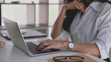 İş kadını evde çalışırken bilgi aramak için dizüstü bilgisayar kullanıyor.