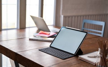 Mockup Dijital Tablet boş ekran ve ofis ekipmanları ahşap masa üzerinde.