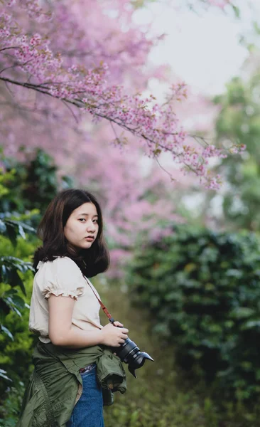 Asiática Adolescente Chica Con Una Cámara Pie Mirándolo Bajo Cerezo —  Fotos de Stock