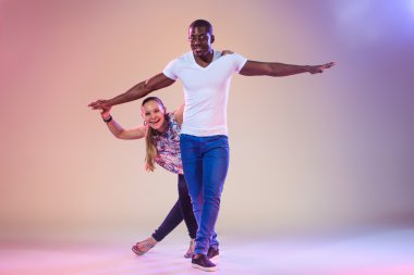 Young couple dances social Caribbean Salsa, studio shot clipart