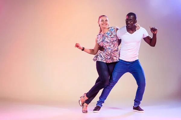 对年轻的夫妇跳社会加勒比萨尔萨舞，工作室拍摄 — 图库照片