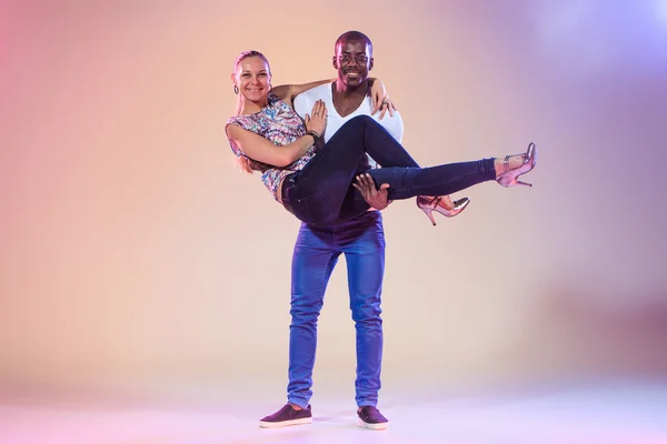 Young couple dances social Caribbean Salsa, studio shot — Stock Photo, Image