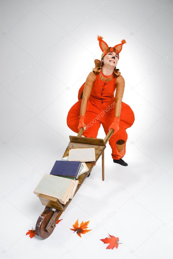 Young woman in image of squirrel with cart and books