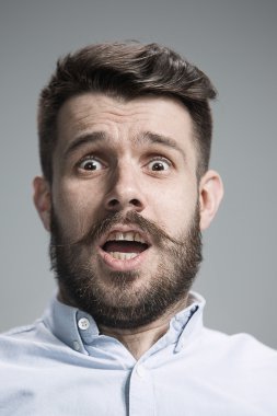 Adam korkmuş görünüyor. Gri arka plan üzerinde