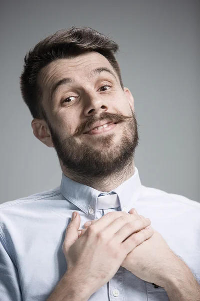 Man is looking imploring over gray background — Stok Foto