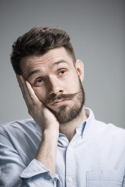 Man is looking bored. Over gray background — Stock Photo, Image