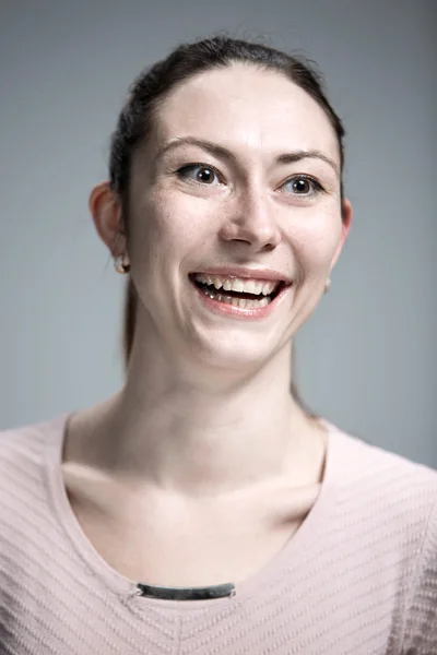 La mujer feliz sobre fondo gris — Foto de Stock