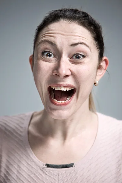 Portrait of young woman with shocked facial expression — Stock Photo, Image