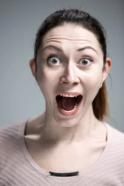 Portrait of young woman with shocked facial expression — Stock Photo, Image