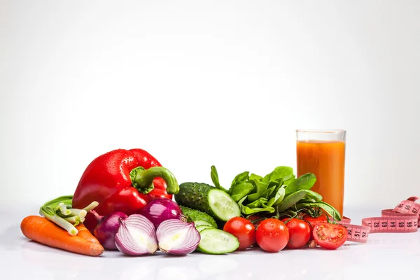 Le ruban à mesurer avec tomates et légumes sur blanc — Photo