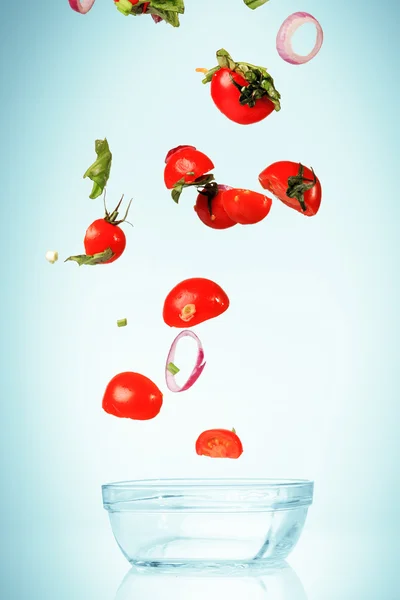 The vegetables for salad falling on blue — Stock Photo, Image