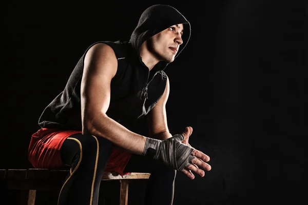 The muscular man sitting and resting on black — Stock Photo, Image