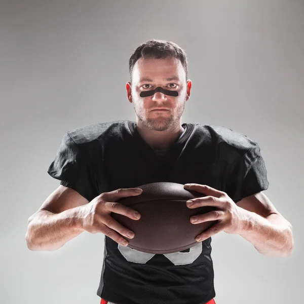 American Football-Spieler posiert mit Ball auf weißem Hintergrund — Stockfoto