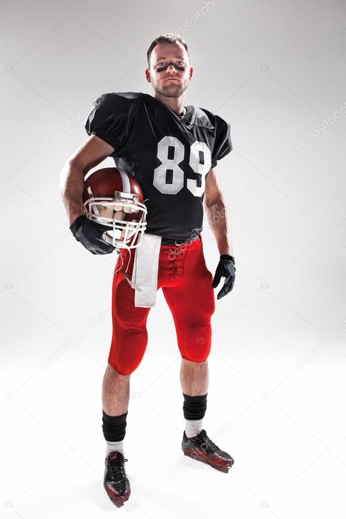 American football player posing with ball on white background