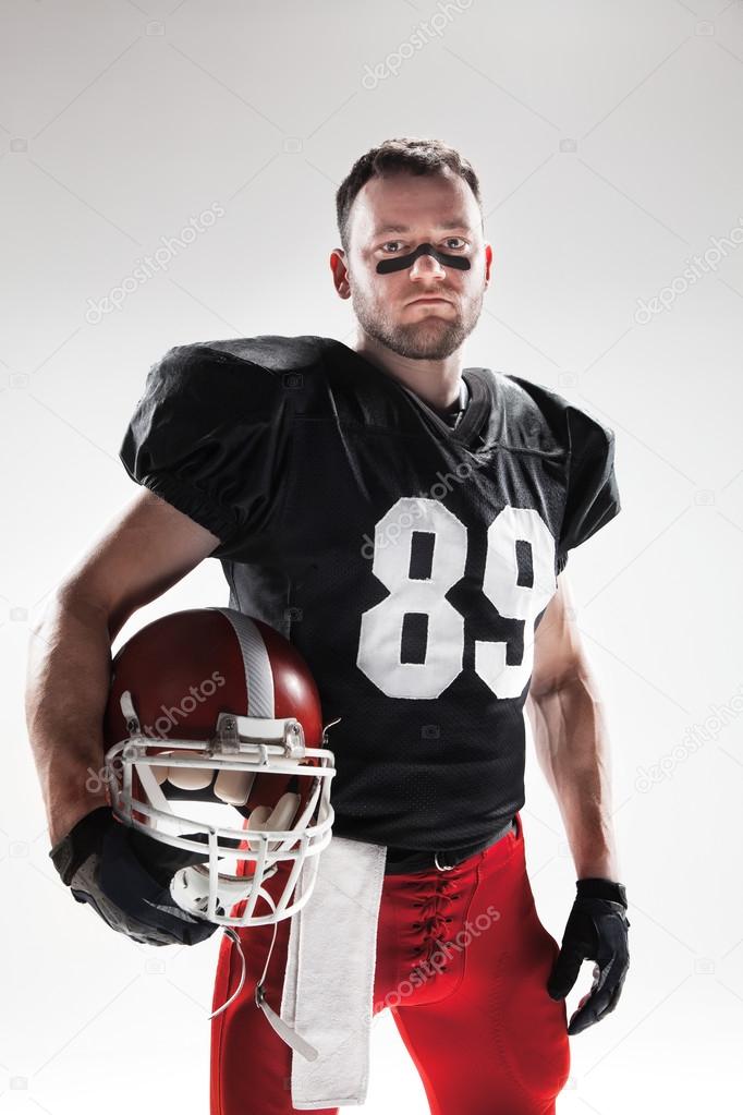 American football player posing with ball on white background