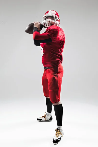 American football speler poseren met bal op witte achtergrond — Stockfoto