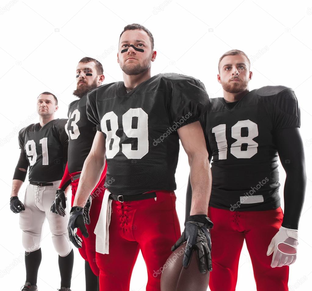 The four american football players posing with ball on white background