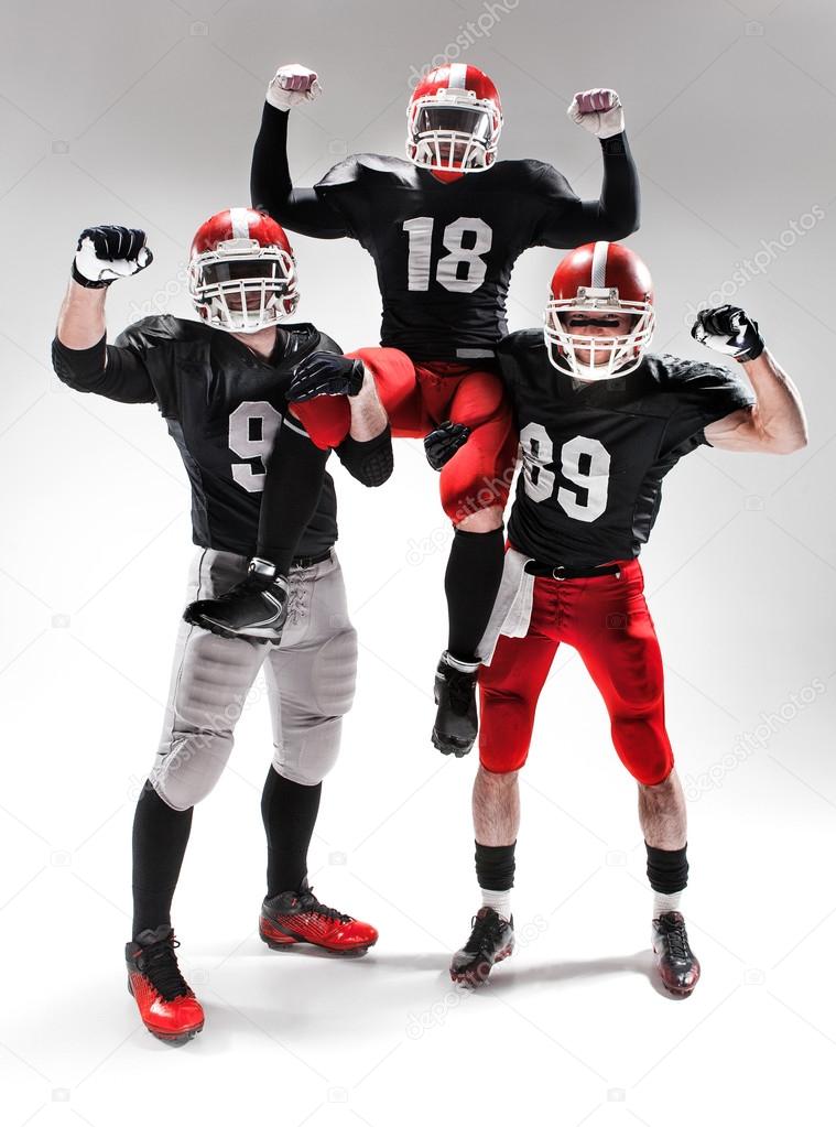 The three american football players posing on white background