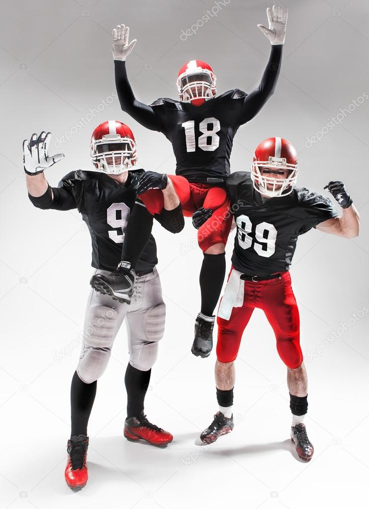 The three american football players posing on white background