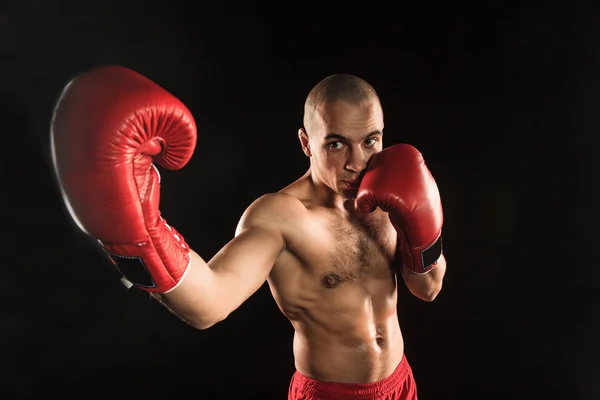 The young man kickboxing on black — Stock Photo, Image