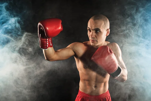 The young man kickboxing in blue smoke — Stock Photo, Image