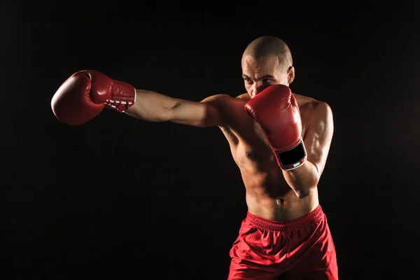 The young man kickboxing on black — Stock Photo, Image