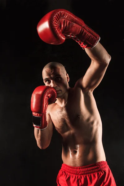 The young man kickboxing on black — Stock Photo, Image