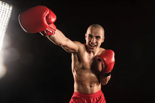 The young man kickboxing on black — Stock Photo, Image
