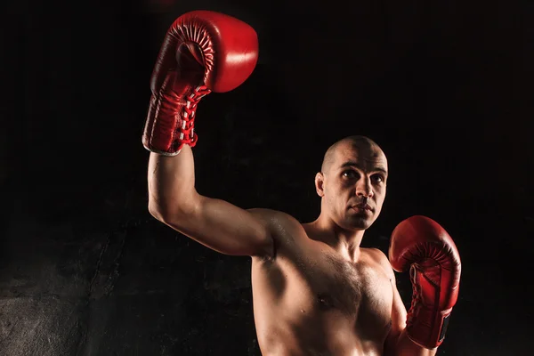 The young man kickboxing on black — Stock Photo, Image